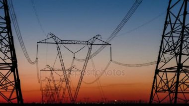 Yüksek gerilim elektrik iletim kulesi enerji pilon. Gün batımı. Isı pus. Timelapse.