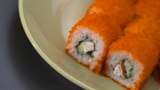 Sushi-Rolle, kalifornische Rollen auf einem Teller mit Essstäbchen, mariniertem Ingwer und Wasabi. Nahaufnahme. — Stockvideo