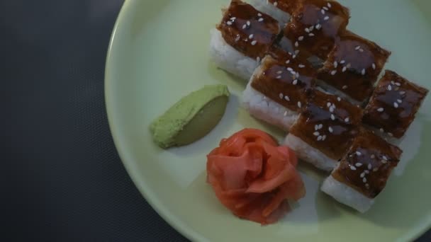 "Dragon "vierkante Sushi broodjes met paling, zalm, komkommer, nori, sushi rijst, sesam. Plaat. Gemarineerde gember en wasabi. Close-up. — Stockvideo