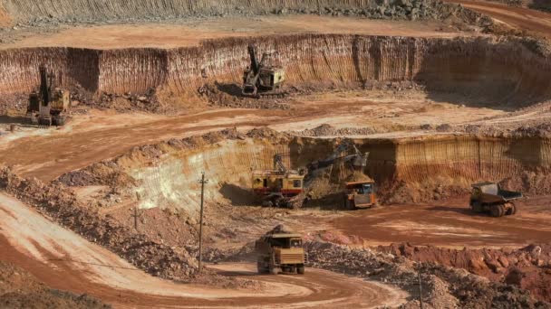 Excavators load ore into dump-trucks. This area has been mined for buaxite, aluminum and other minerals. Open-cast. Operating mine. Bauxite quarry. — Stock Video