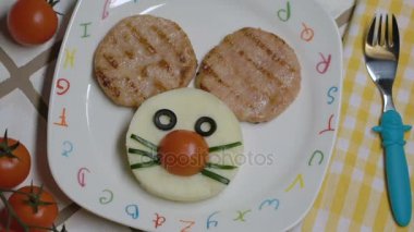 Yaratıcı eğlenceli çocuklar - fare namlu iki tavuk biftek ve patates püresi ile beyaz plaka plaka üzerinde yuvarlak bir şekil için gıda boyalı harfleri.