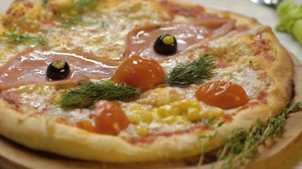 Pizza na forma de um rosto engraçado com um bigode das folhas de endro, olhos de azeitonas e um nariz de um tomate. A pizza está decorada com folhas de endro. Movimento lento . — Vídeo de Stock