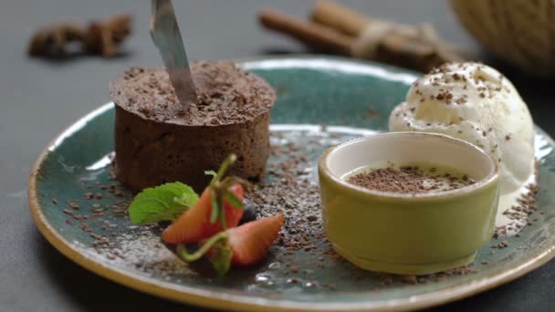 Chocolade lava cake Fondant geserveerd met ijs. Cake wordt gesneden met een mes. De vloeibare room stroomt uit. Slow motion. — Stockvideo