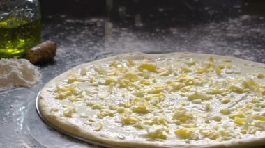 Pizza yemek. Taze rendelenmiş peynir pizza hamuru için ekleme eller. Pizza malzemeleri unlu ahşap masa üzerinde. Ağır çekim.