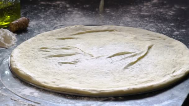 Μαγείρεμα πίτσα. Χέρια προσθέτοντας φρέσκο άσπρη σάλτσα στη ζύμη για πίτσα. Πίτσα συστατικών στο αλευρωμένη ξύλινο τραπέζι. Αργή κίνηση. — Αρχείο Βίντεο