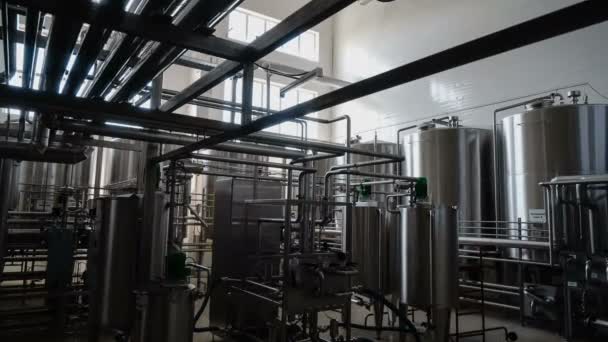 Wide zoom-in shot of industrial interior. Robotic factory line for processing and quality control of pure spring water bottled into canisters. — Stock Video