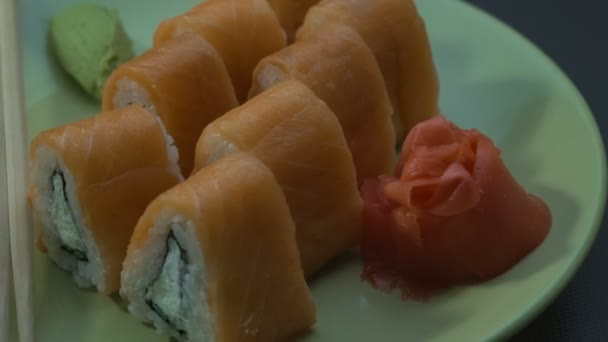 Driehoekige sushi rolt Philadelphia op een plaat. Close-up. — Stockvideo