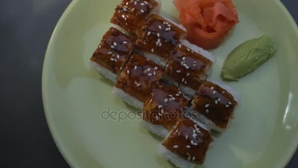 Appetizing incrível "Dragon" rolos de sushi quadrados com enguia, salmão, pepino, nori, arroz sushi, sésamo. Placa. Gengibre marinado e wasabi. Close-up . — Vídeo de Stock