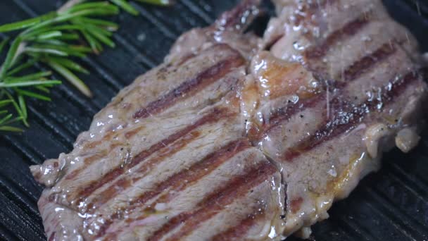 Rindersteak auf dem Grill wird mit Salz bestreut. Zeitlupe. — Stockvideo