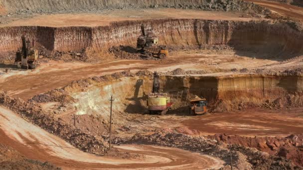 Graafmachines laden erts in de dump-vrachtwagens. Dit gebied is voor buaxite, aluminium en andere mineralen gedolven. Open-cast. Operationele mijne. Bauxiet steengroeve. — Stockvideo