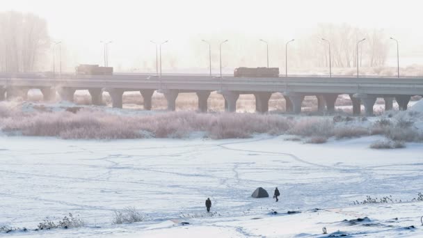 Amplio tiro de puente de carretera que cruza el río congelado en invierno en el helado amanecer de niebla . — Vídeos de Stock