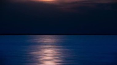 Zaman atlamalı, güneş ile göl üzerinde kara bulutlar hareket ile alacakaranlık yansımaları ışınları.