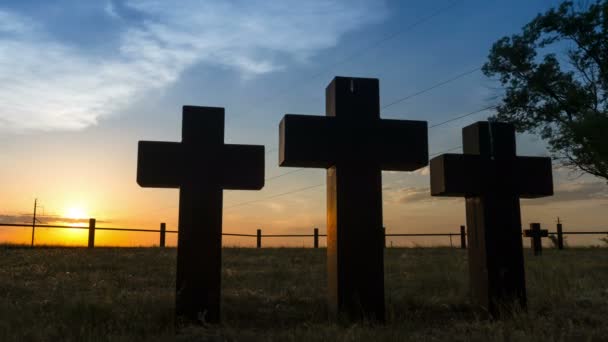 Tracking shot of Three massive stone crosses on the graves of the old cemetery against time lapse of clear blue sky with moving sun. — Stock Video