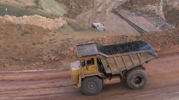 Plan médian de camions lourds chargés de cargaison dans une carrière minière à ciel ouvert lors d'une journée ensoleillée d'été. Carrière minière de bouxite . — Video