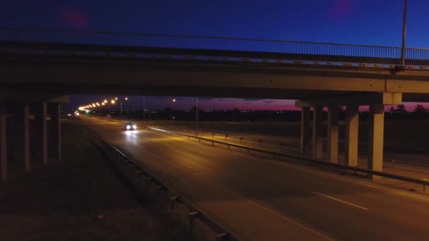 Aerial view. Traffic at illuminated highway interchange. Evening traffic. — Stock Video