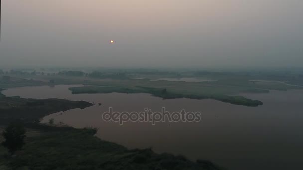 Вид с воздуха. Панорамный летний пейзаж утром. Живописный пейзаж с рекой, деревьями и полем с невероятным солнцем. Утренний туман . — стоковое видео