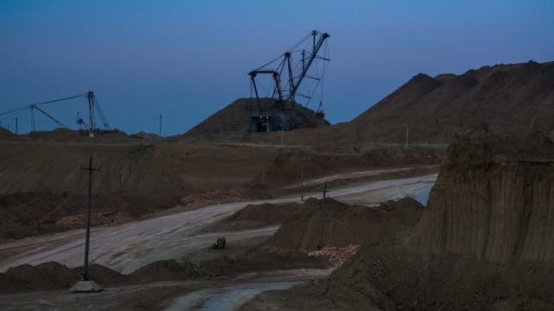 Weitwinkelaufnahme des Bergwerks mit Baggern, die in der Abenddämmerung Erz verladen. Rückansicht eines vorbeifahrenden Muldenkippers. Bauxitabbau. — Stockvideo