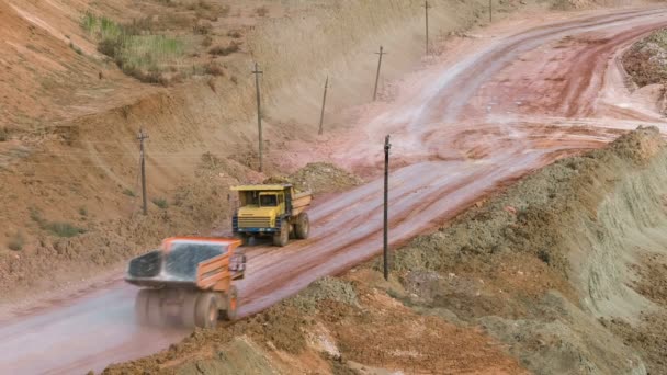 Mid shot of heavy mining trucks carring cargo in opencast mining quarry in sunny summer day. Cantera minera de Bouxita . — Vídeos de Stock