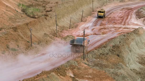 Mid shot of heavy mining trucks carring cargo in opencast mining quarry in sunny summer day. Cantera minera de Bouxita . — Vídeo de stock