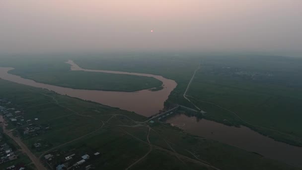 Vista aérea. Paisaje panorámico de verano por la mañana. El pintoresco paisaje con río, presa en el río, árboles y campo con sol increíble. Niebla matutina . — Vídeos de Stock