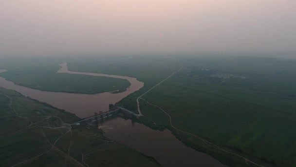 Luftaufnahme. panoramische Sommermorgen-Landschaft. die malerische Landschaft mit Fluss, Damm am Fluss, Bäumen und Feld mit unglaublicher Sonne. Morgennebel. — Stockvideo