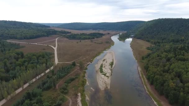 Vista aérea de montañas cubiertas de bosque de coníferas con río . — Vídeos de Stock