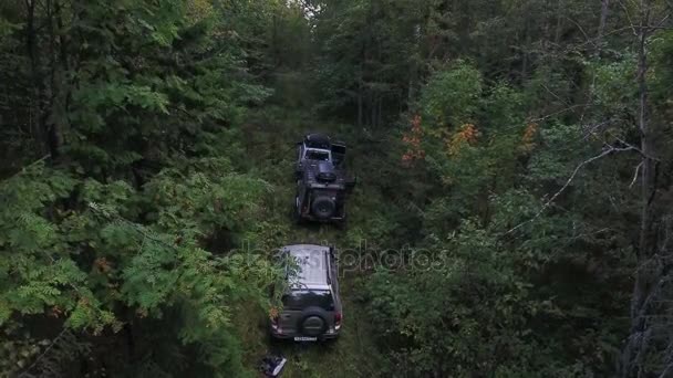 Zdjęcia lotnicze odchylana z trzy Suv samochody parking w lesie gęste górskie. — Wideo stockowe