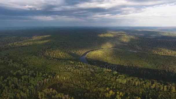 Foto aérea de montañas cubiertas de bosque de coníferas con rayos de río y sol a través de las nubes . — Vídeos de Stock