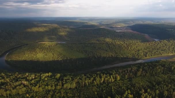 Luchtfoto van bergen bedekt met naaldhout bos met rivier en de zon stralen door de wolken. — Stockvideo