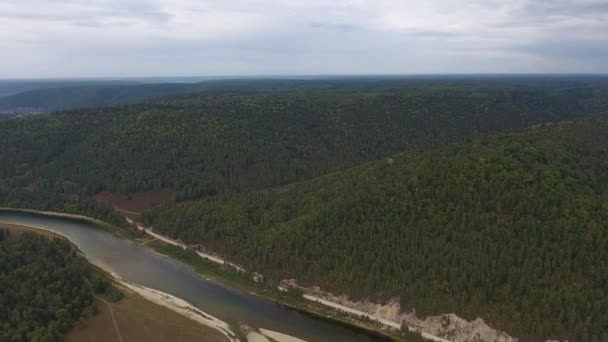 Vista aérea de montañas cubiertas de bosque de coníferas con río . — Vídeos de Stock