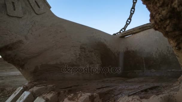 Colpo ravvicinato di benna escavatore dragline inclinabile a mano 15 metri cubi con massicce catene in piedi sul lato della cava contro il tramonto sul cielo blu . — Video Stock