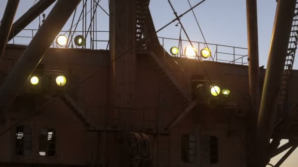 Handschuss eines superschweren Dragline-Baggers mit Scheinwerfern auf der Seite des Steinbruchs gegen Sonnenuntergang am blauen Himmel. — Stockvideo