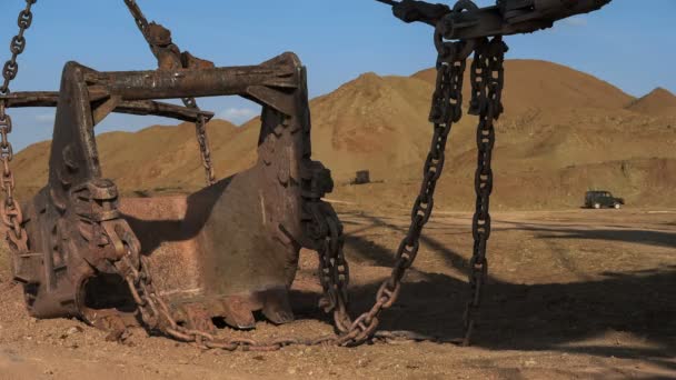 Breiter Schuss Dragline Baggerschaufel 15 Kubikmeter mit massiven Ketten stehen auf der Seite des Steinbruchs gegen Sonnenuntergang am blauen Himmel. — Stockvideo