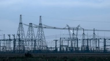 Bir yüksek gerilim Trafo Merkezleri, günbatımında. İletim elektrik hatları. Isı pus.