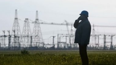 Geniş kask Smartphone'da enerji Trafo Merkezi teftiş sırasında konuşurken ciddi Danışmanı, çekim.