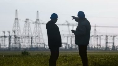 Geniş iki Smartphone'da enerji Trafo Merkezi teftiş sırasında konuşurken bir şey tartışırken baret mühendislerince shot.