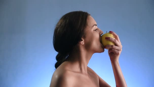 Närbild porträtt av Sexig ung brunett kvinna bitande och äta välsmakande gult äpple i slow motion. — Stockvideo