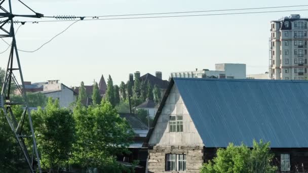 Weitwinkelaufnahme der Stadt nähert sich mit altem Holzhaus neben den Hochhaus-Wohnhäusern. — Stockvideo