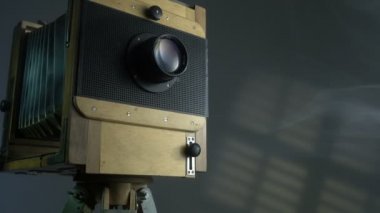 İzleme gri arka planda güneşlikler ile güneş ışığı tarafından eski vintage ahşap fotoğraf kamera aydınlatma atış zoom.