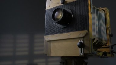 Düşük açılı zum atış dışarı eski izleme vintage ahşap fotoğraf kamera aydınlatma perdeleri gri arka planda aracılığıyla güneş ışığı tarafından.