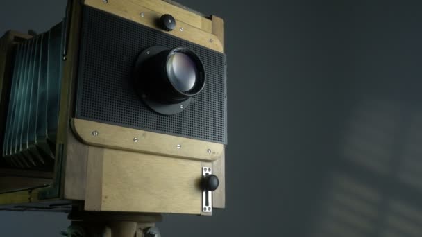 Отслеживание зума снимка старой винтажной деревянной фотокамеры освещения солнечным светом через жалюзи на сером фоне . — стоковое видео