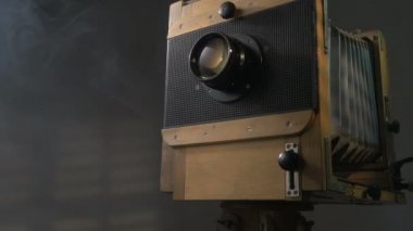 Düşük açılı zum atış dışarı eski izleme vintage ahşap fotoğraf kamera aydınlatma perdeleri gri arka planda aracılığıyla güneş ışığı tarafından.