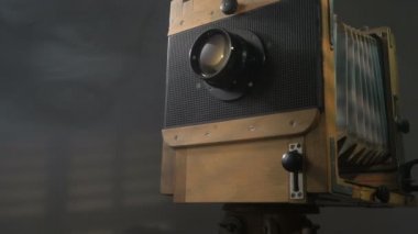 Düşük açılı zum atış dışarı eski izleme vintage ahşap fotoğraf kamera aydınlatma perdeleri gri arka planda aracılığıyla güneş ışığı tarafından.