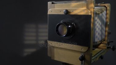 Yakın eski vintage ahşap fotoğraf kamera aydınlatma görüntüsünü uzaklaştırmak kadar güneş ışığı gri arka planda güneşlikler üzerinden izleme.