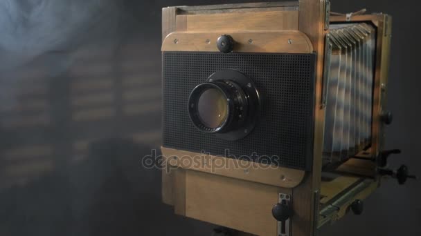 Tracking dicht omhoog uitzoomen schot van oude vintage houten foto camera verlichting door zonlicht door de blinds in de grijze achtergrond. — Stockvideo