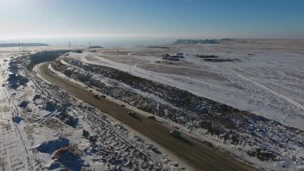 Vista aérea de três suvs se movendo ao longo da estrada no deserto no inverno. Cazaquistão Ocidental, Península de Mangyshlak . — Vídeo de Stock