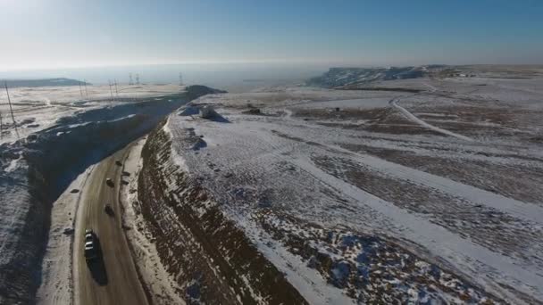Luftaufnahme von drei Geländewagen, die sich im Winter auf der Autobahn in der Wüste bewegen. Westkasachstan, Halbinsel Mangyshlak. — Stockvideo