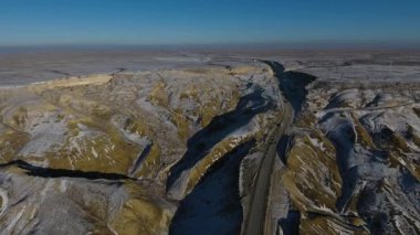 Kamyon ve çölde yolu boyunca kışın hareketli SUV'lar havadan görünümü. Batı Kazakistan, Mangışlak Yarımadası.