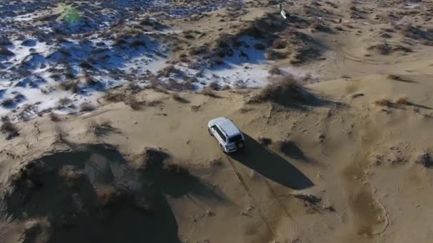 Veduta aerea del SUV che si muove nel deserto innevato in inverno. Kazakistan occidentale, penisola di Mangyshlak . — Video Stock
