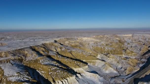 Geweldige luchtfoto van de zanderige bergen sneeuw-bekleding in West Kazakhstan, Mangyshlak schiereiland. Woestijn in de sneeuw. — Stockvideo